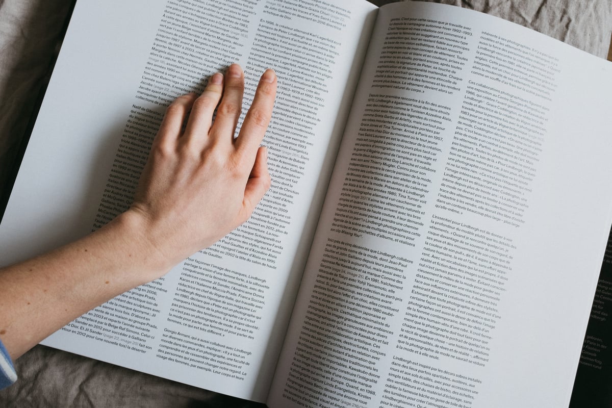 Faceless woman reviewing article in book